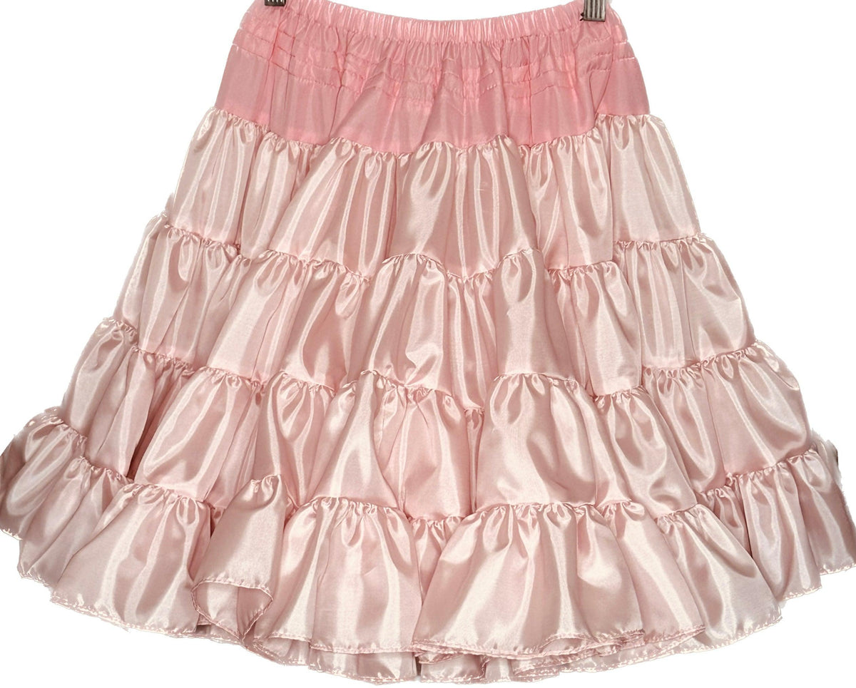 A Soft Poly-Liner Petticoat in pink, ruffled polyester, from Square Up Fashions, hanging on a hanger.