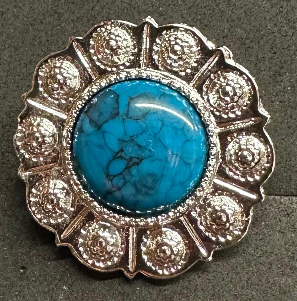 The Western Express Turquoise Scarf Slide features a bright blue marbled stone at the center, scalloped silver-plated edge, measures 1.25" across, and is made in the USA. Shown on a gray surface.