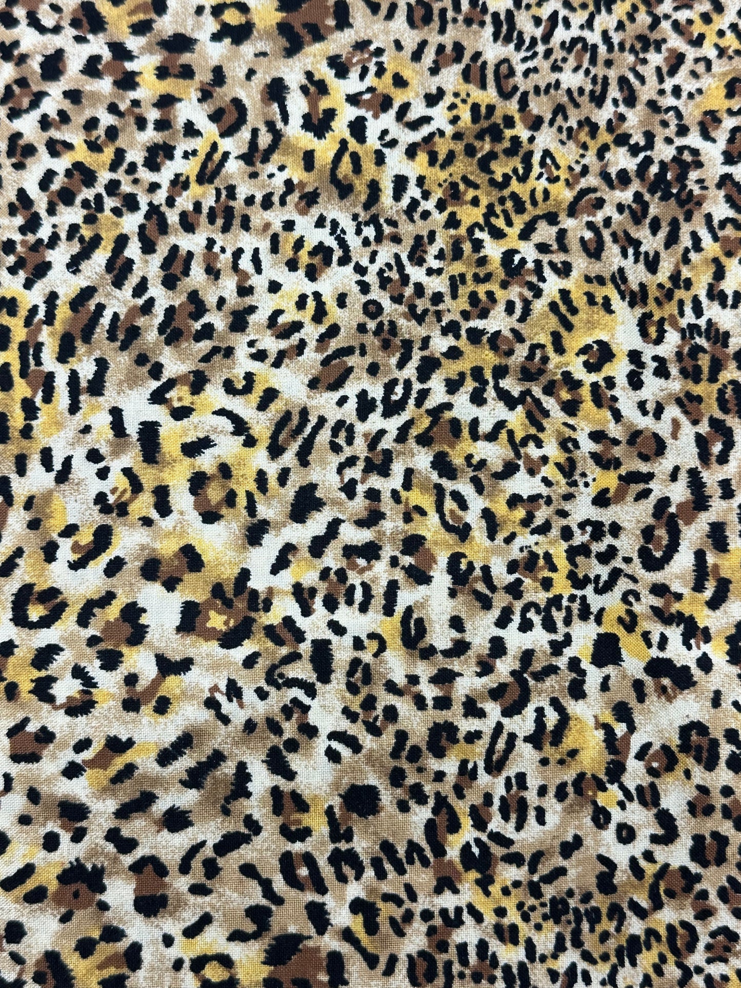 A close-up of the Wild Animal Print Outfit by Square Up Fashions shows leopard cheetah fabric with black, brown, and yellowish spots on a light background.