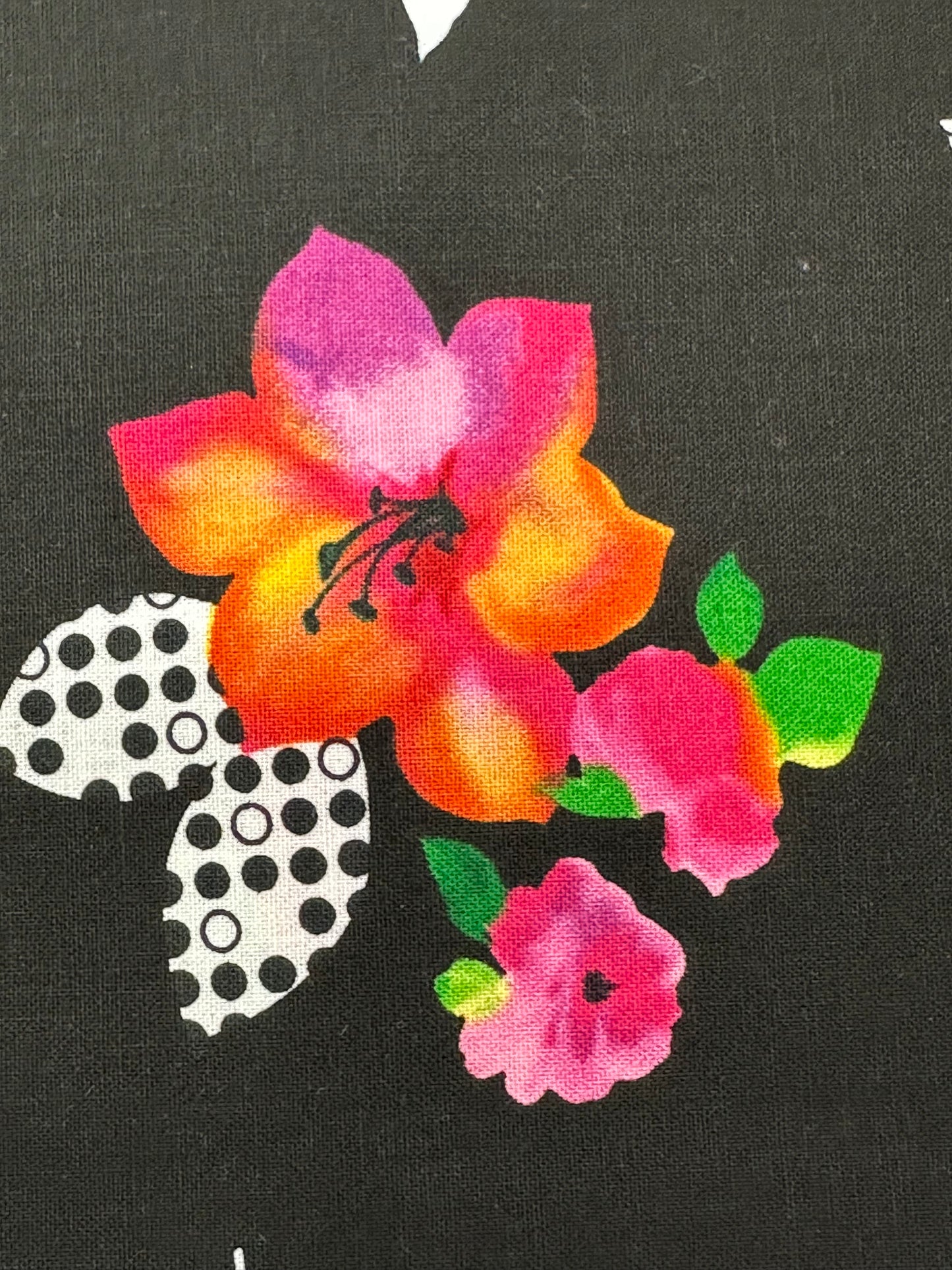 The Colorful Floral Poppies Skirt by Square Up Fashions features vibrant pink, orange, and yellow flowers with green leaves and black-and-white polka dot leaf shapes on a dark background.