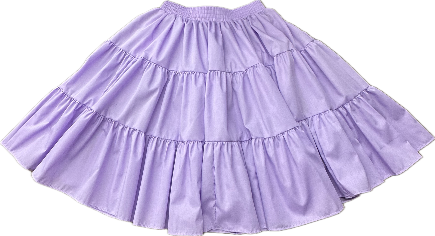 The Square Up Fashions Basic 3 Tier Square Dance Skirt is knee-length, features an elastic waistband, and comes in light purple fabric. Shown flat on a white background. Available in several colors.