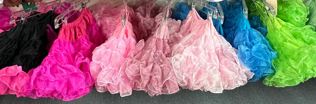 CLEARANCE Childrens Crystal Petticoat skirts with elastic waistband hanging on a rack.