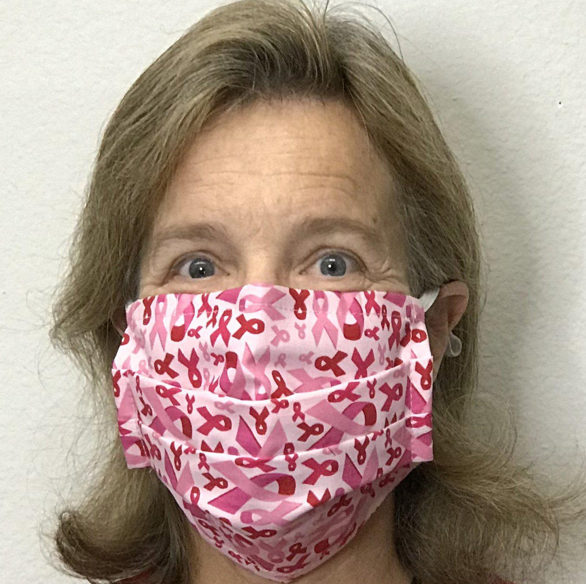 A woman wearing a Square Up Fashions pink camouflage face mask with adjustable nose wire for enhanced fit and comfort.