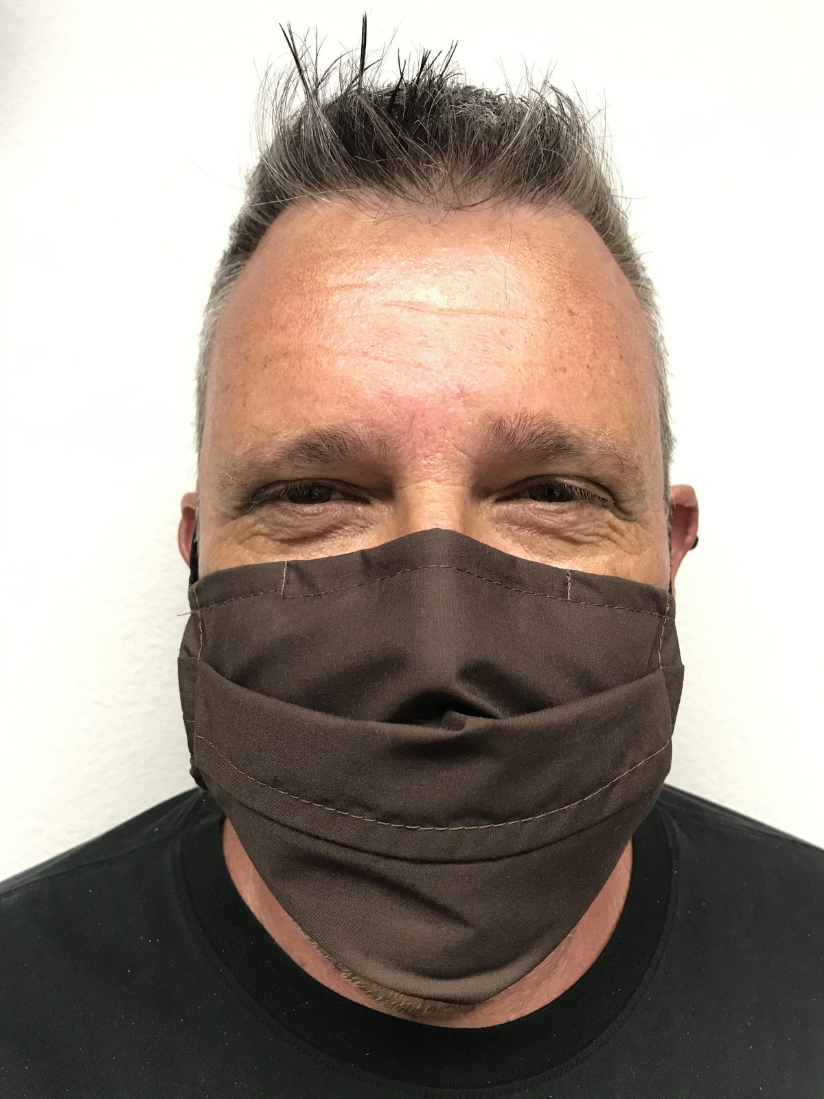 A man wearing a Square Up Fashions brown face mask with adjustable nose wire.