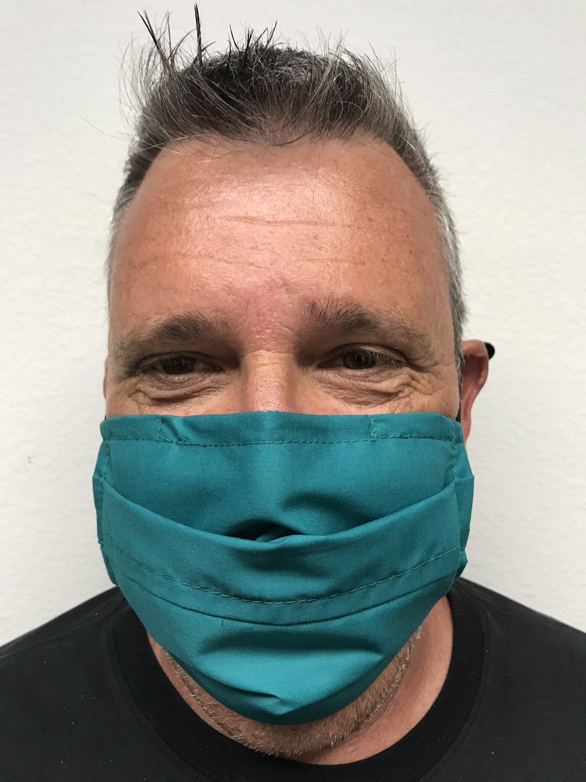 A man wearing a Square Up Fashions green face mask with adjustable nose wire, providing 2 layers of protection. The mask is washable &amp; reusable.
