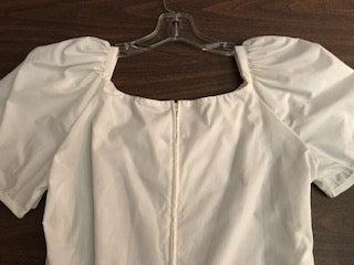 A Square Up Fashions Sweetheart Neck Blouse hanging on a hanger.
