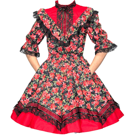 The Holiday Poinsettia Square Dance Outfit by Square Up Fashions features red and black poinsettia prints, black lace trim, ruffled details, and elbow-length sleeves—perfect for festive holiday events.