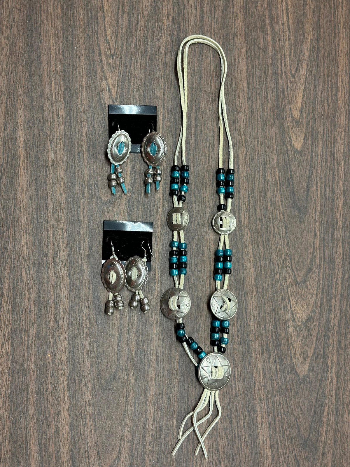 A matching set of Square Up Fashions&#39; Concho Necklace and earrings adorned with turquoise beads.