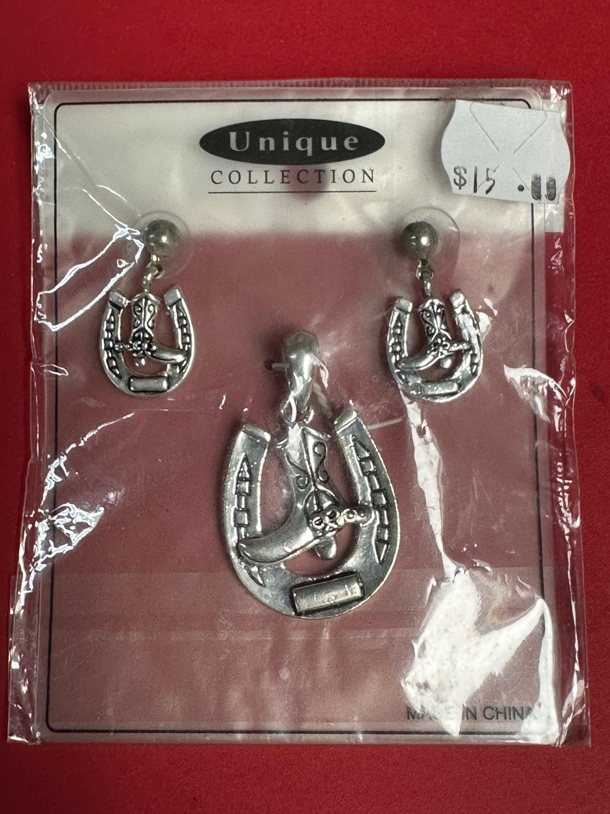 A Square Up Fashions horseshoe necklace charm and earrings set in a package.