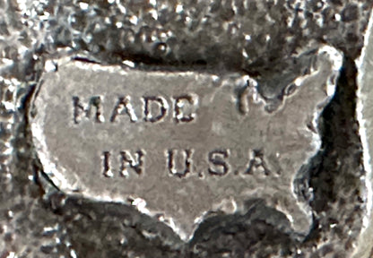 The Square Up Fashions "Square Dance Buckle w/ instruments" is a metal buckle featuring musical designs, reminiscent of a vintage square dance accessory from the 1988 Anaheim National event.