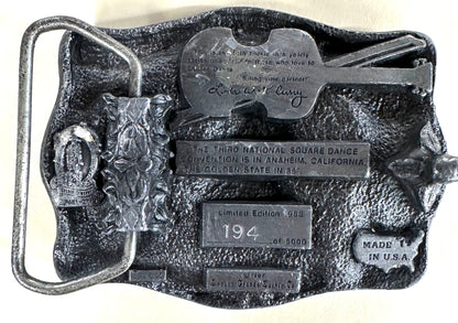 This limited edition Square Up Fashions Square Dance Buckle w/ instruments commemorates the 33rd National Square Dance Convention, 1988 Anaheim. Numbered 194 of 5000, it features a silver finish with a guitar and engraved details.