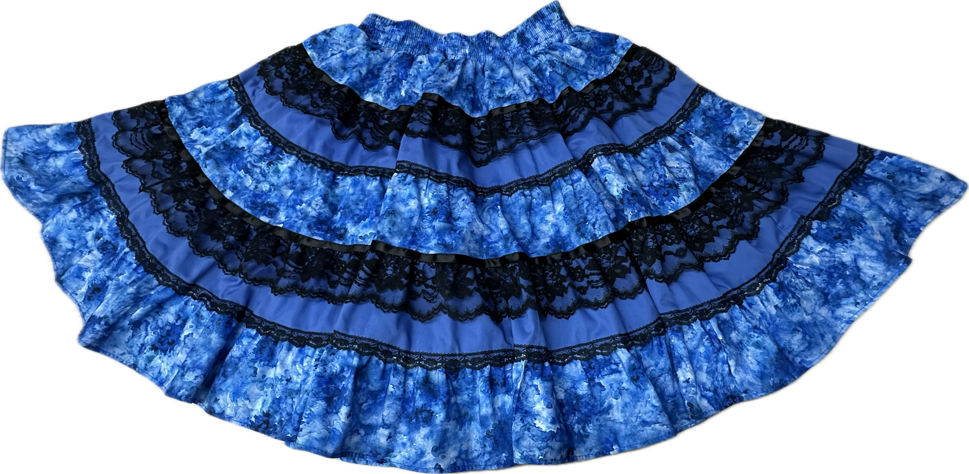The Tone on Tone Square Dance Skirt by Square Up Fashions is a wide, blue, ruffled tiered skirt with black lace trim shown flat on a white background.
