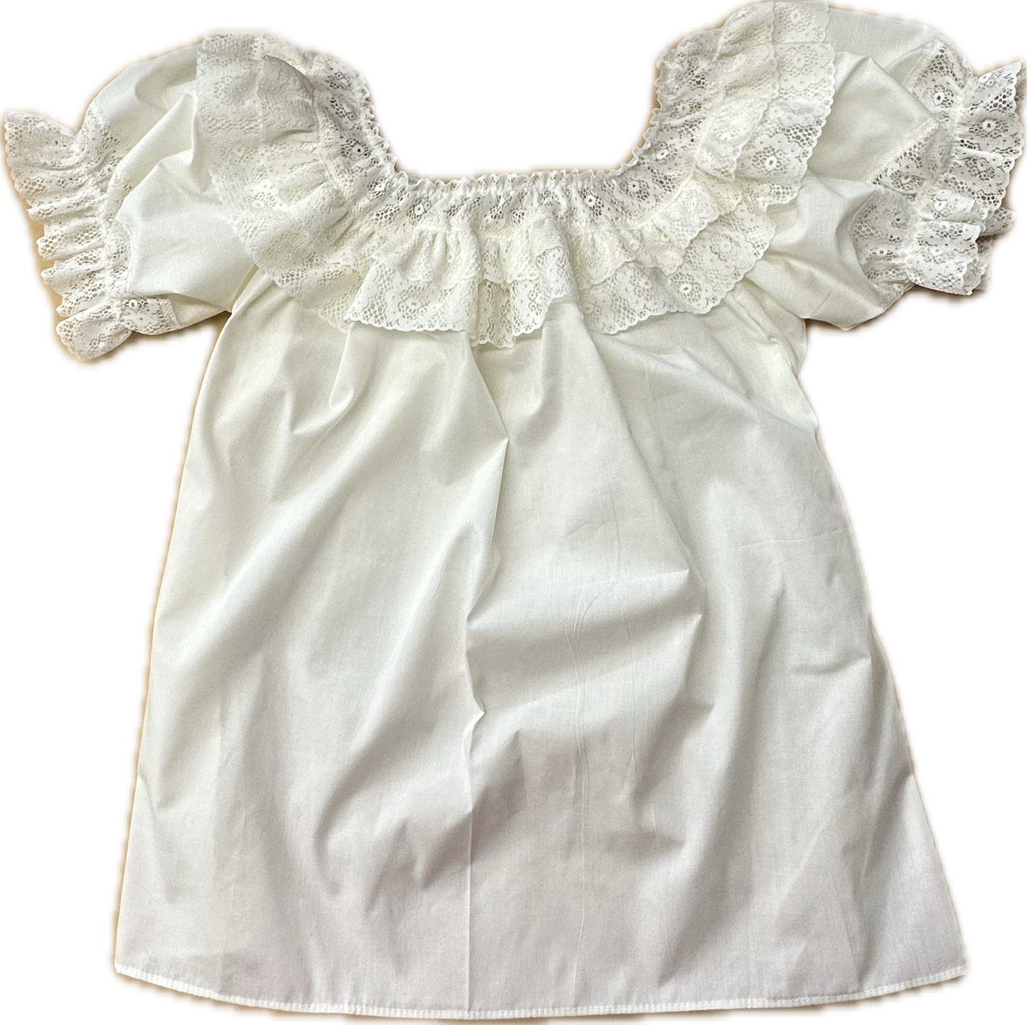 The Fiesta Laced Round Neck Blouse by Square Up Fashions features white cotton, short ruffled fiesta lace sleeves, and a delicate lace ruffle at the neckline, shown laid flat on a plain background.
