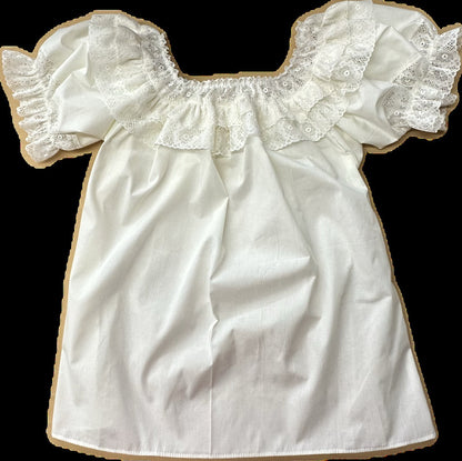The Fiesta Laced Round Neck Blouse by Square Up Fashions features white cotton, short ruffled fiesta lace sleeves, and a delicate lace ruffle at the neckline, shown laid flat on a plain background.