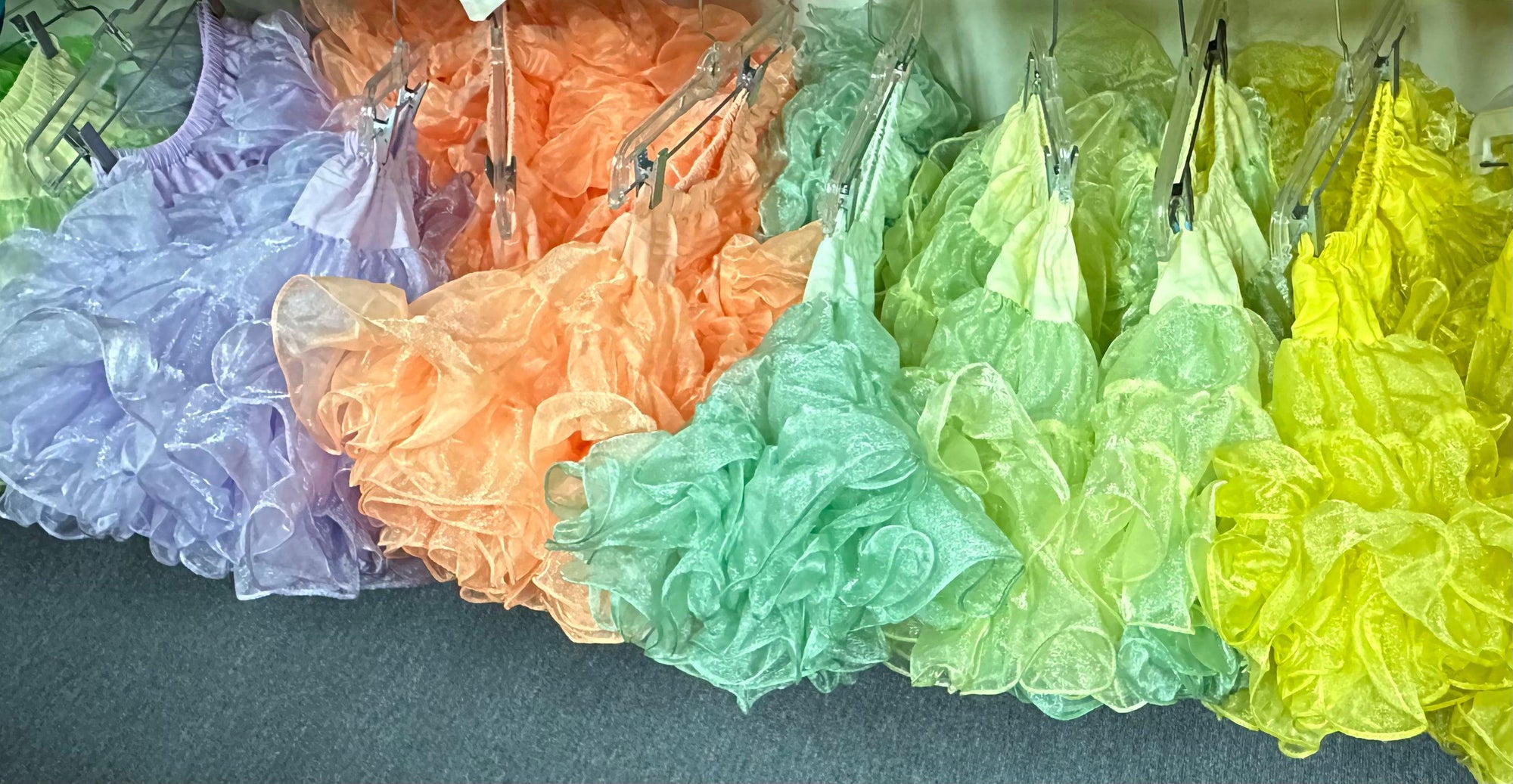 CLEARANCE Childrens Crystal Petticoat skirts made of nylon fabric hanging on a rack by Square Up Fashions.