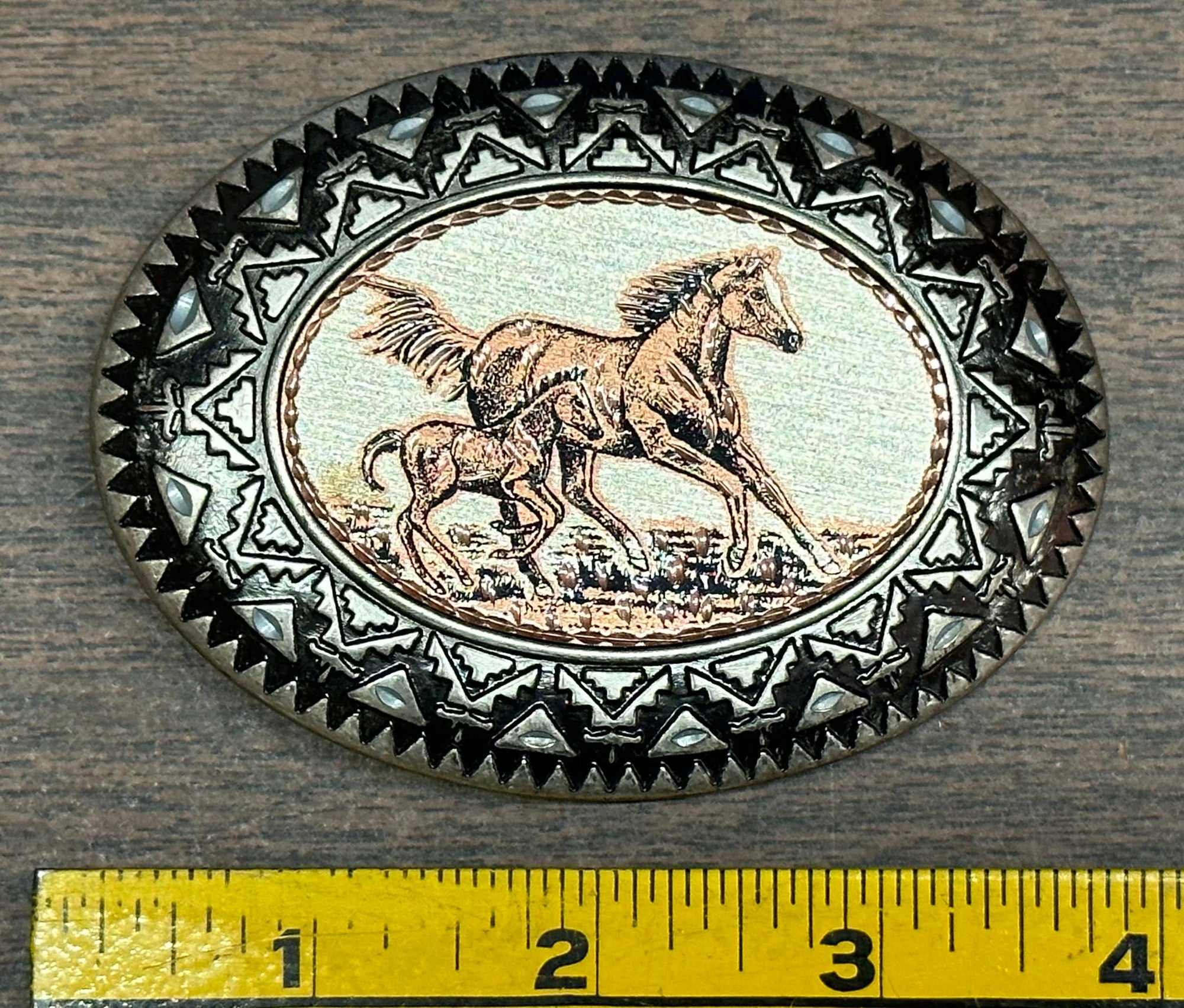 A Square Dance Buckle from Square Up Fashions, featuring a horse and foal, perfect for adding a touch of wilderness to your outfit.